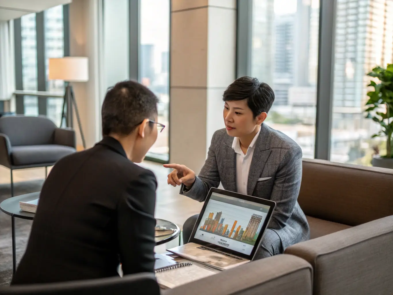 An investor reviewing property portfolios with a consultant in a modern office setting, discussing investment strategies.